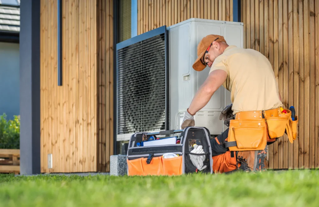 A-Comfort Service technician installing a new outdoor HVAC unit at a residential property.