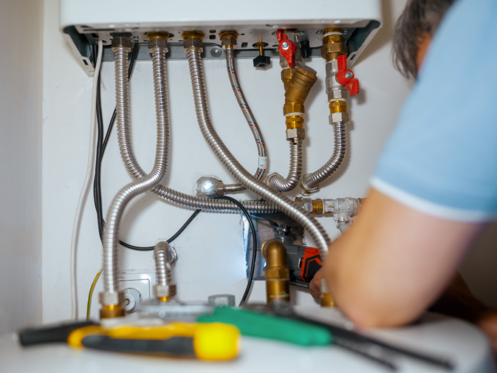 Professional installation of flexible stainless steel water lines and brass valves for a residential boiler system.